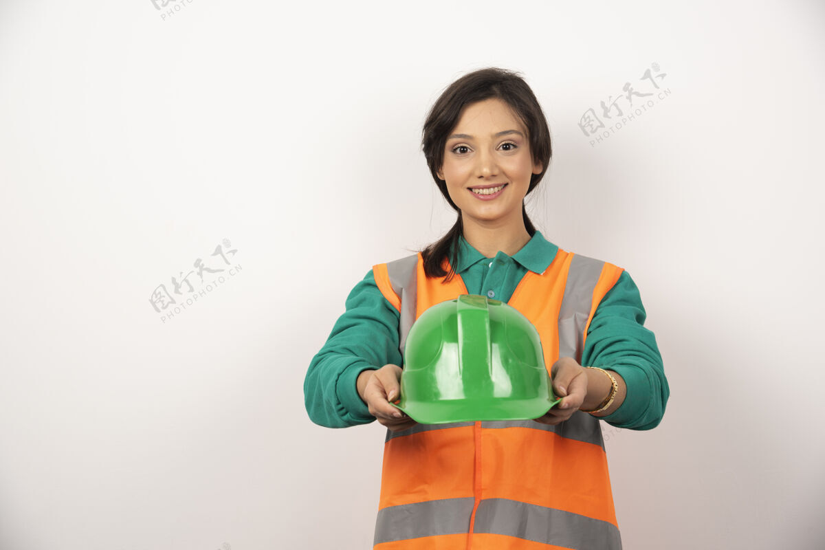 女性微笑的女工程师手持白色背景的头盔工作企业建筑师