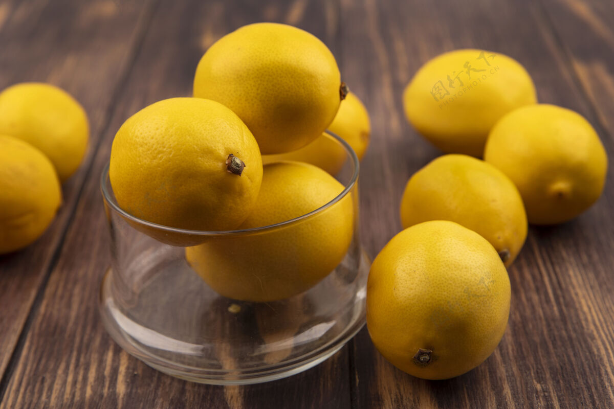 块玻璃碗上酸味柠檬的俯视图 柠檬被隔离在木制表面上厨房水果味道