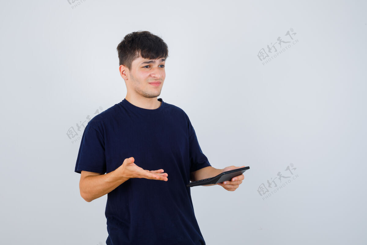 男人一个穿着黑色t恤的年轻人手里拿着计算器 看上去很失望 正对着窗外休闲计算器前面