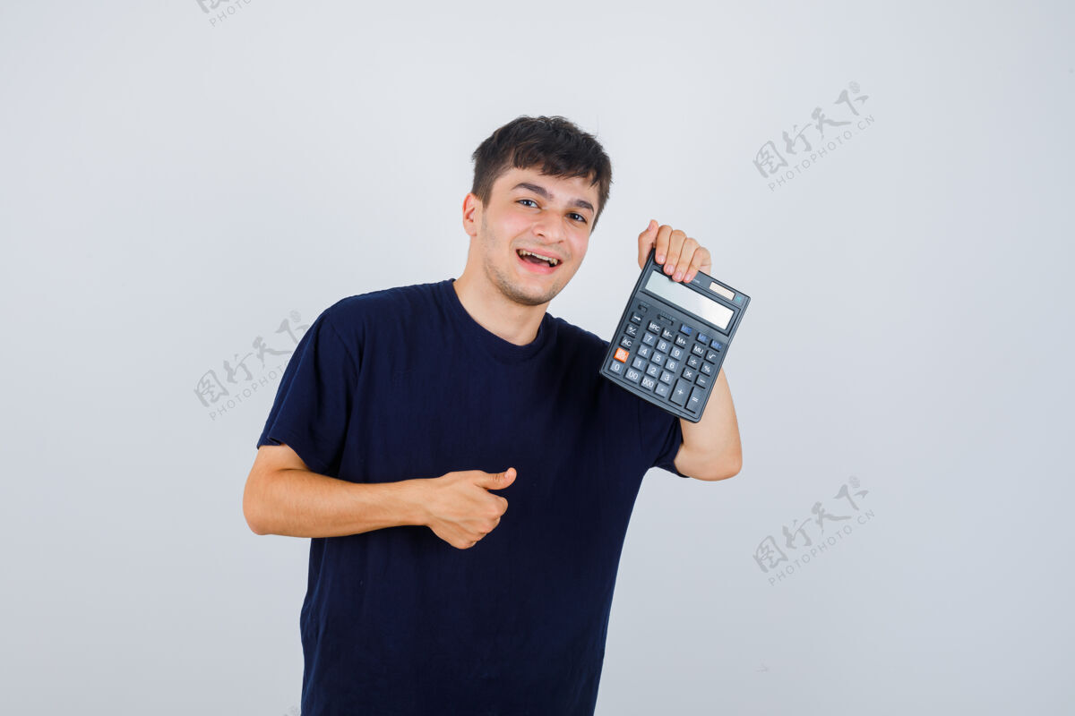 抱着手持计算器的年轻人的肖像 穿着黑色t恤向上竖起大拇指 看上去很高兴看到前面的景色站着商务商务