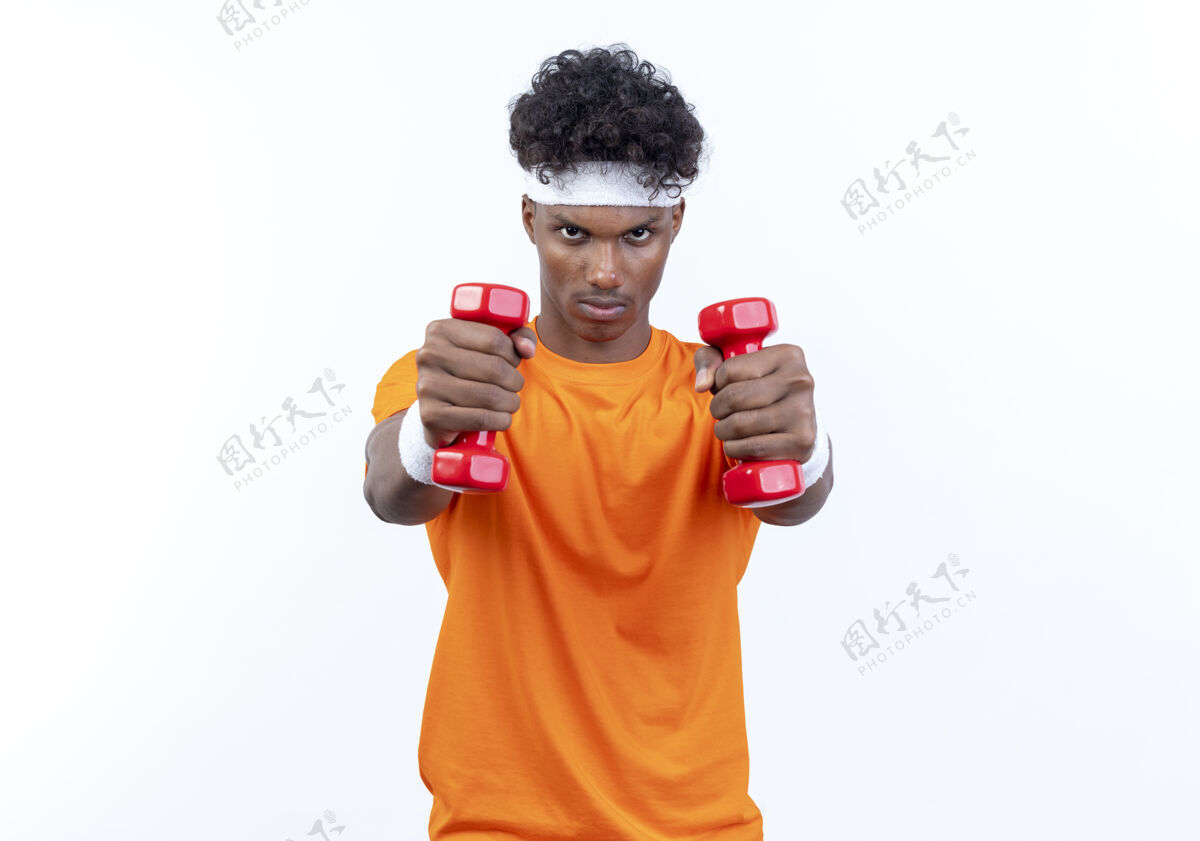 非裔美国人自信的年轻美国黑人运动男子戴着头带和手环举着哑铃腕带穿年轻