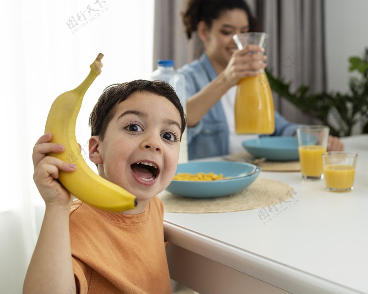 优质时间可爱的小男孩玩香蕉的画像？在早餐桌上餐桌爱关系