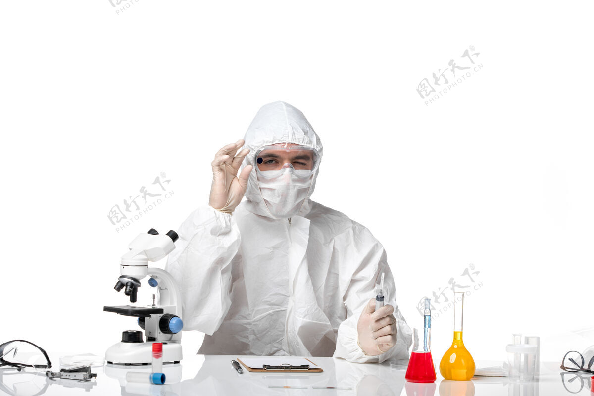 防护正面图：男医生穿着防护服 戴着面罩 因为柯维德在一个浅白色的空间里拿着针剂医生注射到期