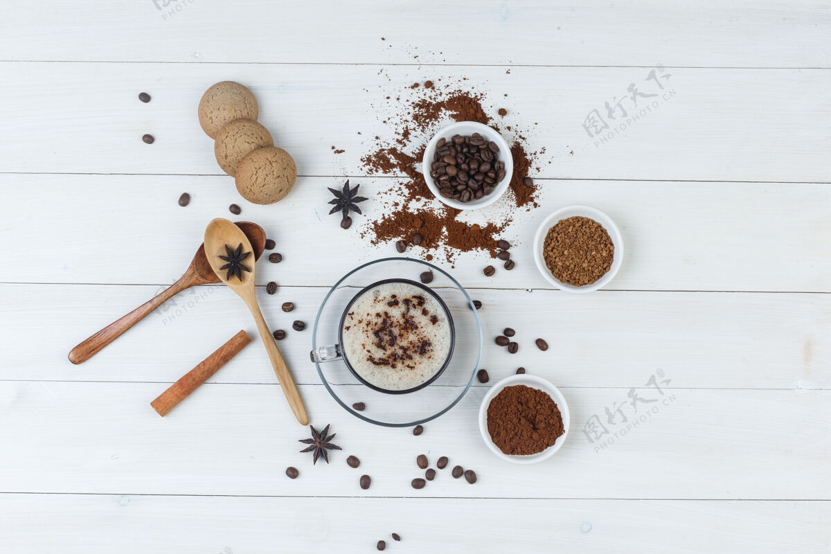 马克杯一套咖啡豆 磨碎的咖啡 香料 饼干 木勺子和咖啡在一个木制的背景杯顶视图味道质地曲奇