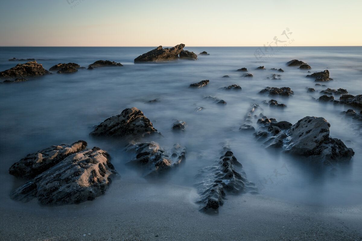 自然美丽的海滨岩石镜头 背景是白色的天空新鲜空气风景海岸