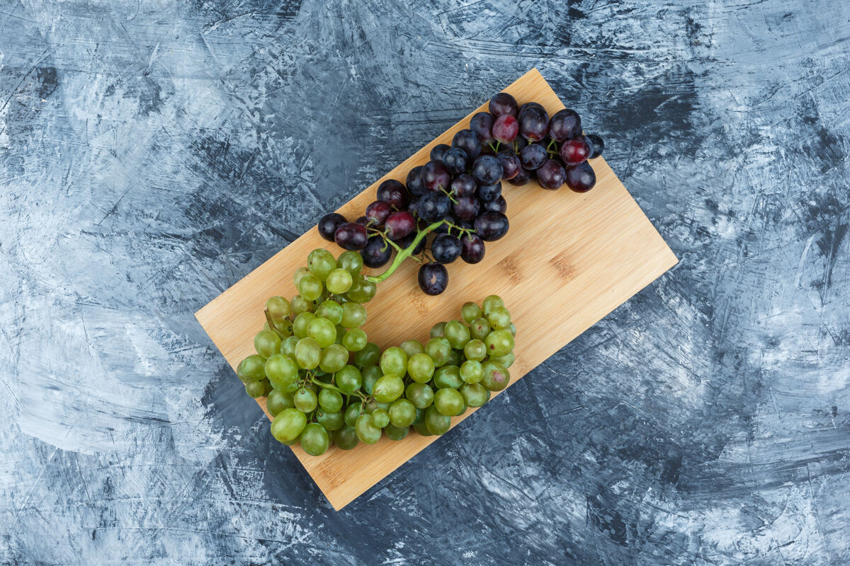 葡萄把新鲜的葡萄平放在粗糙的石膏和砧板上水平石膏切割美味
