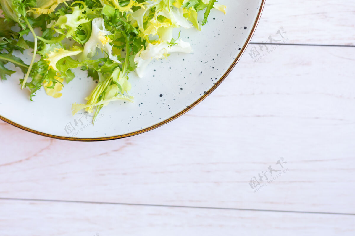 菠菜白色陶瓷盘子 木质表面有新鲜沙拉营养混合午餐