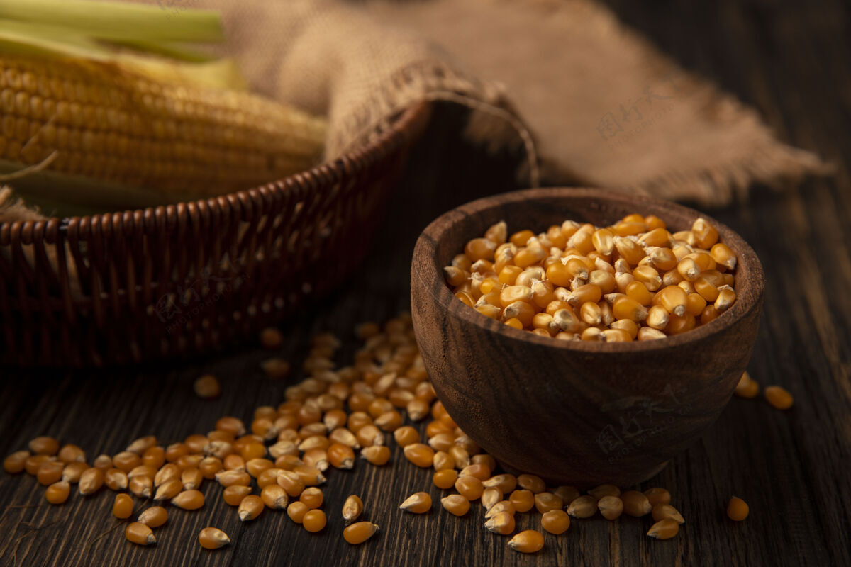 配料顶视图新鲜玉米粒在一个木碗与谷粒孤立在一个木墙上景观新鲜食物