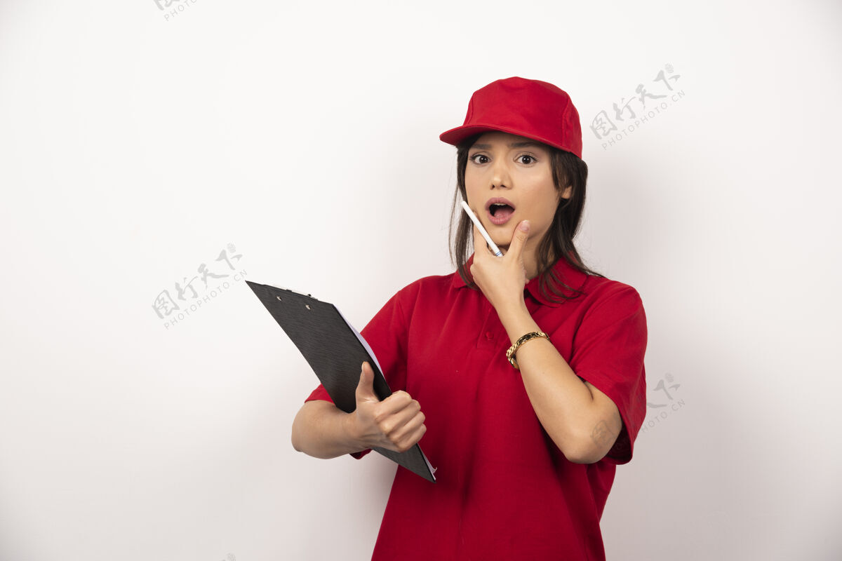 帽子穿着红色制服的年轻女送货员 白色背景上有剪贴板年轻人剪辑路径制服