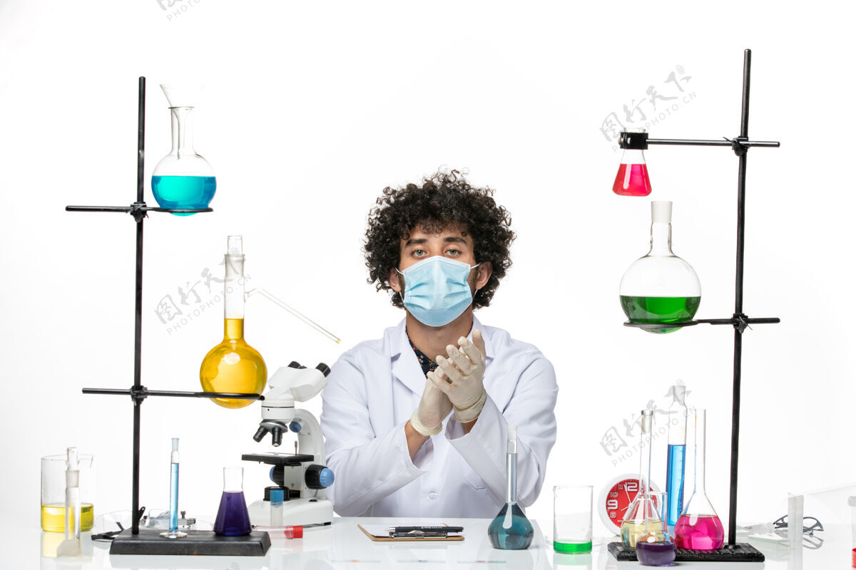 前面正面图男性化学家穿着白色的医疗服 戴着口罩在白色的空间里鼓掌男性化学研究