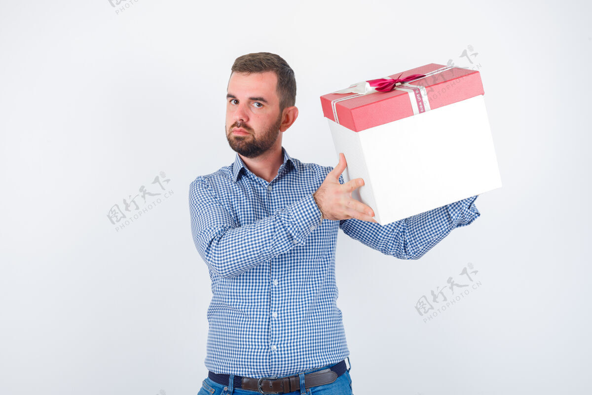 黑发年轻男性手持礼品盒 身着衬衫 目光集中 正面朝前看前面衬衫商人