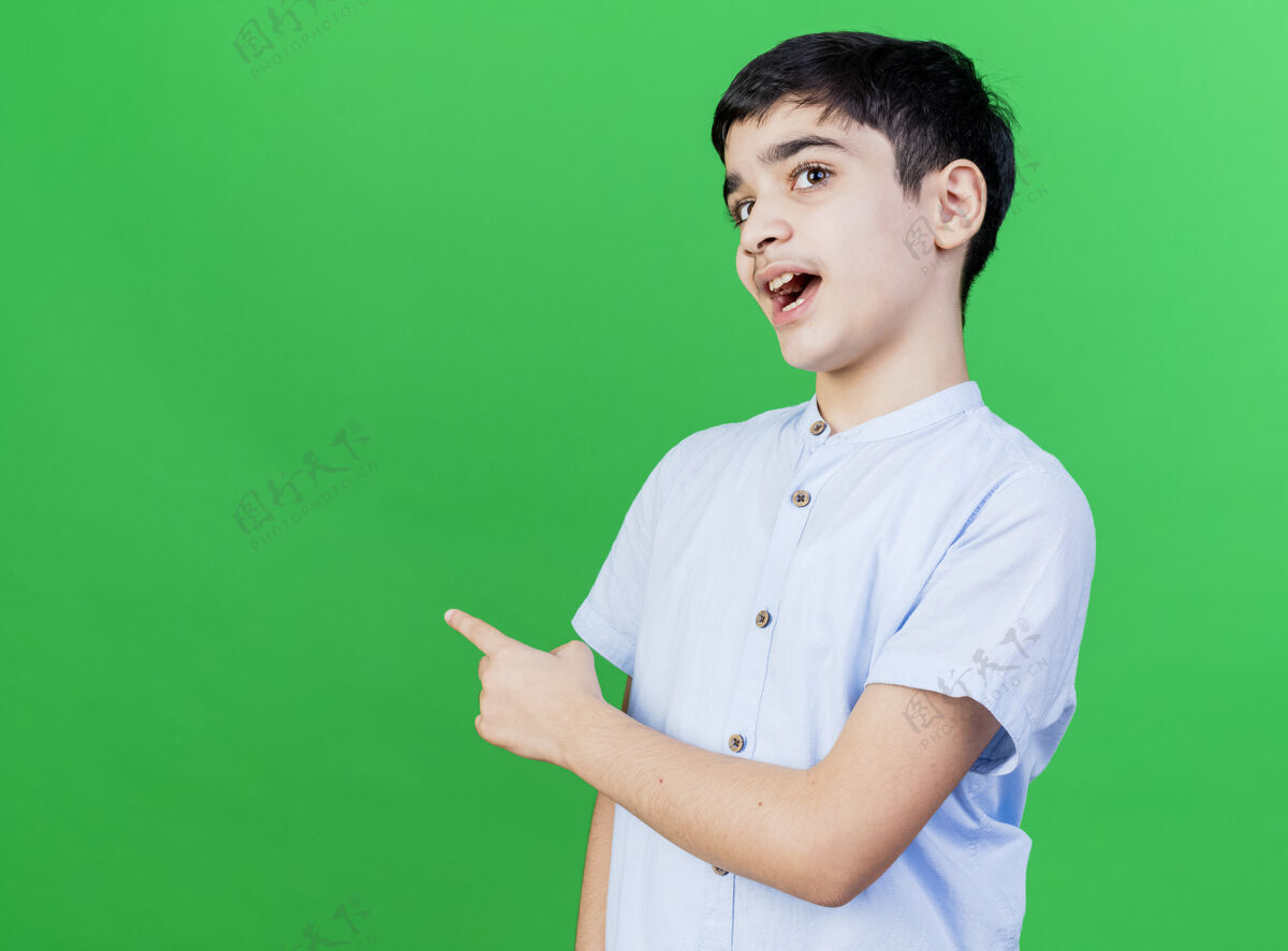 男人令人印象深刻的年轻白人男孩指着后面的绿色隔离墙与复制空间年轻人男孩印象