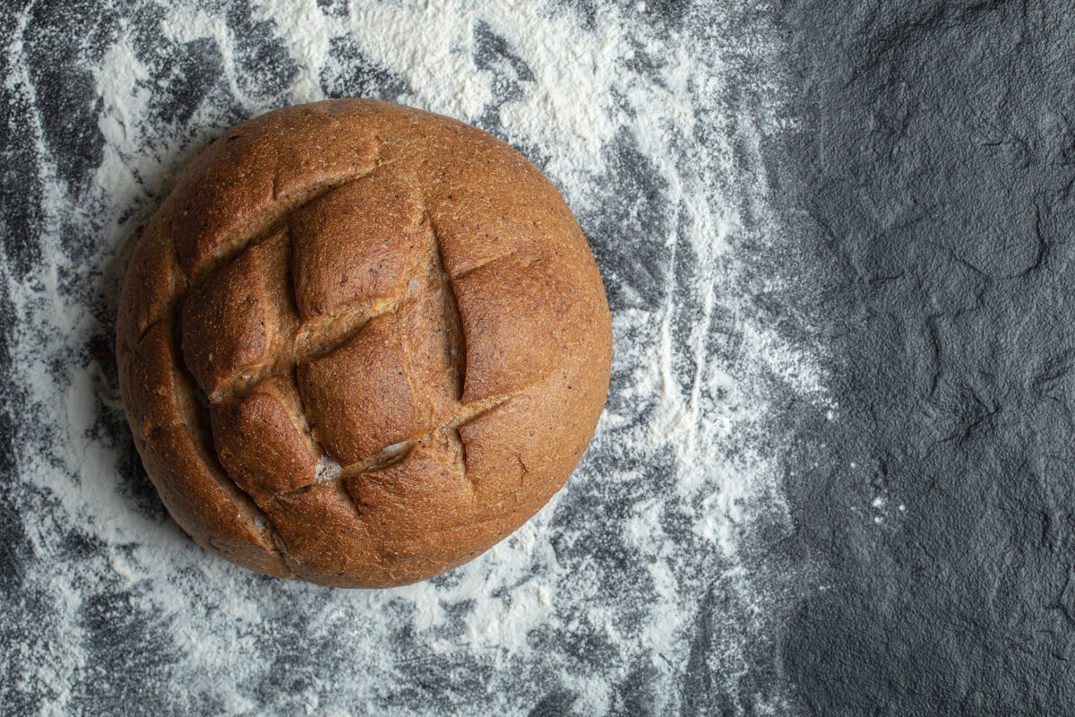 烘焙黑麦面包的特写照片在面粉上早餐健康小吃