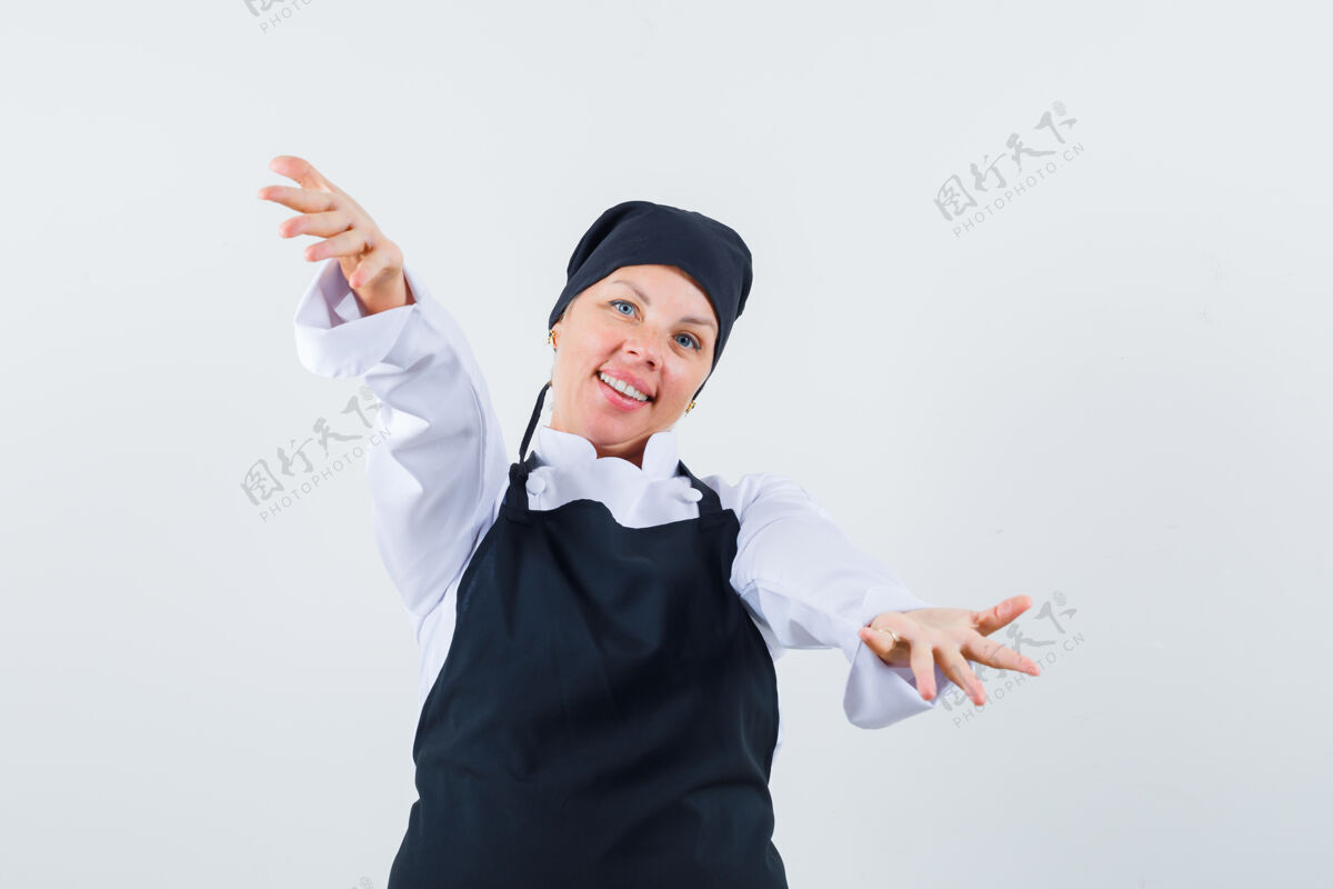 年轻女厨师穿着制服张开双臂拥抱 围裙看起来很可爱 前视图皮肤护理化妆成人