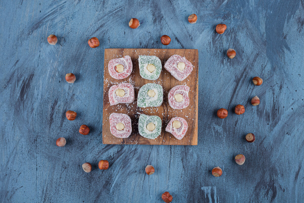 立方体美味的五颜六色的甜点和坚果放在木板上食品东方糖果