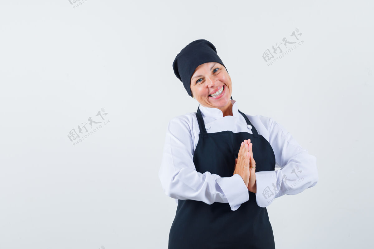 化妆一位金发女郎穿着黑色厨师制服 摆出迷人的姿势正视图健康护理模特