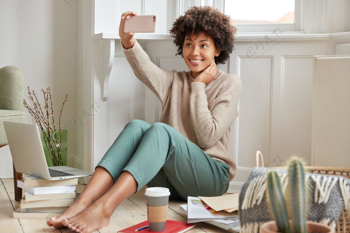 毛衣快乐的黑人混血女子 在手机前自拍女士学习电脑
