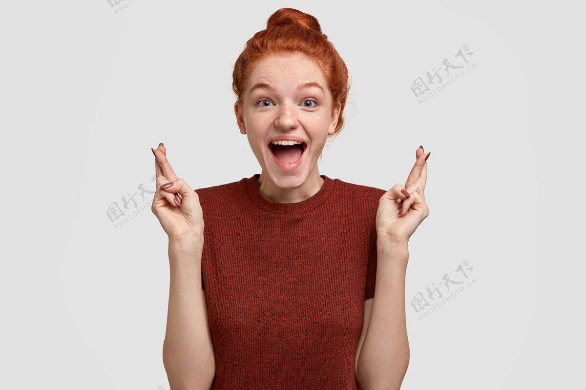 相信积极的人类情感观快乐的满脸雀斑的红发女孩从快乐中张嘴 交叉手指手势T恤情绪