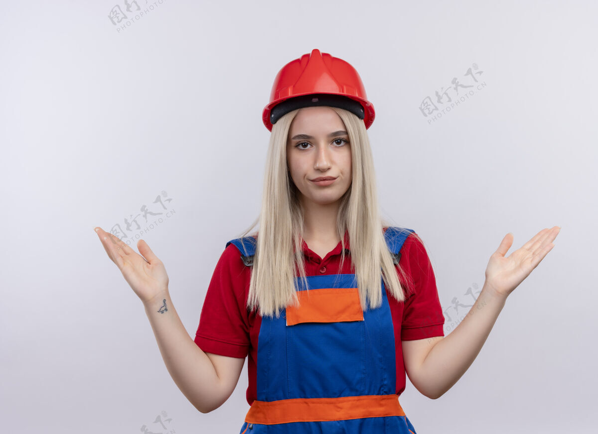 建筑工人穿着制服的年轻金发建筑工女孩在孤立的白墙上空手而归手空显示