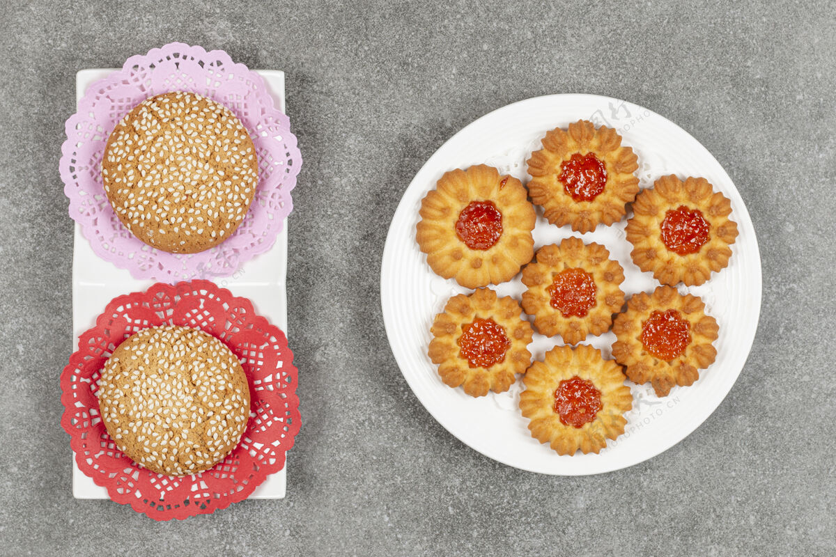 脆两个芝麻饼干和果冻饼干在大理石表面小吃食品果酱