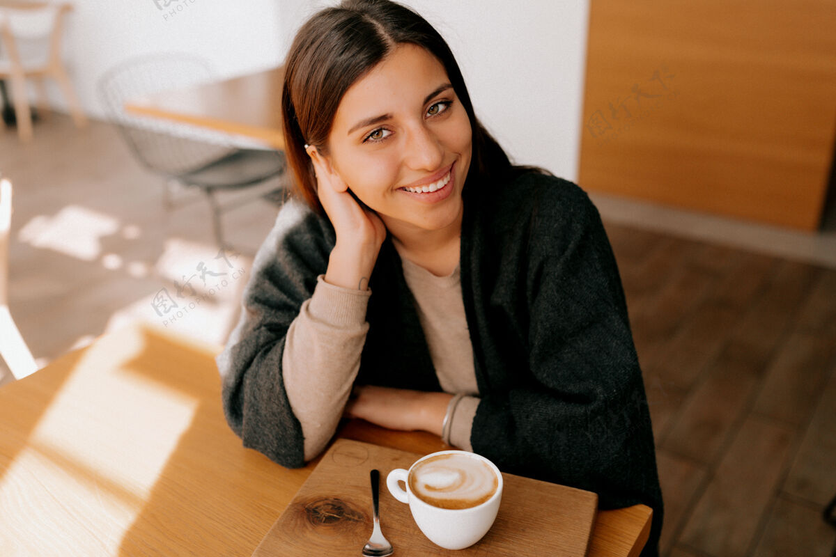 满足坐在咖啡馆里喝咖啡的女人优雅可爱快乐的女人