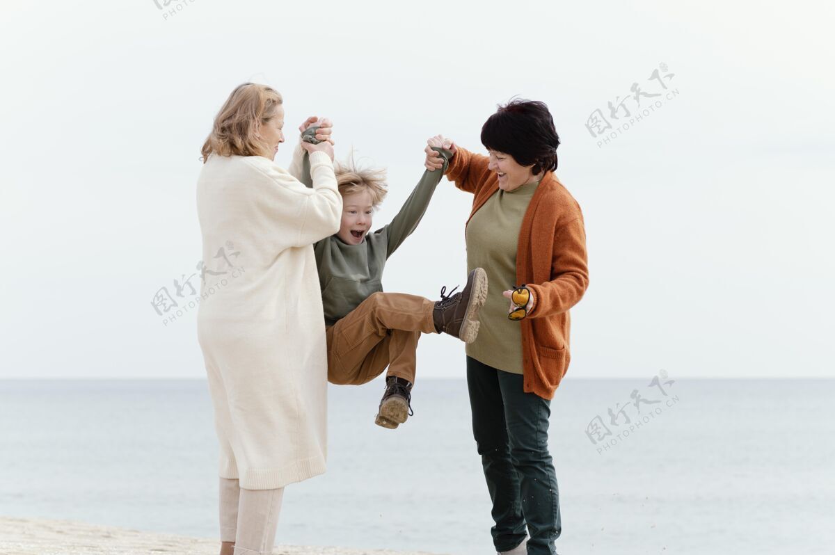 祖父母全镜头女人和孩子玩得开心娱乐海滩童年