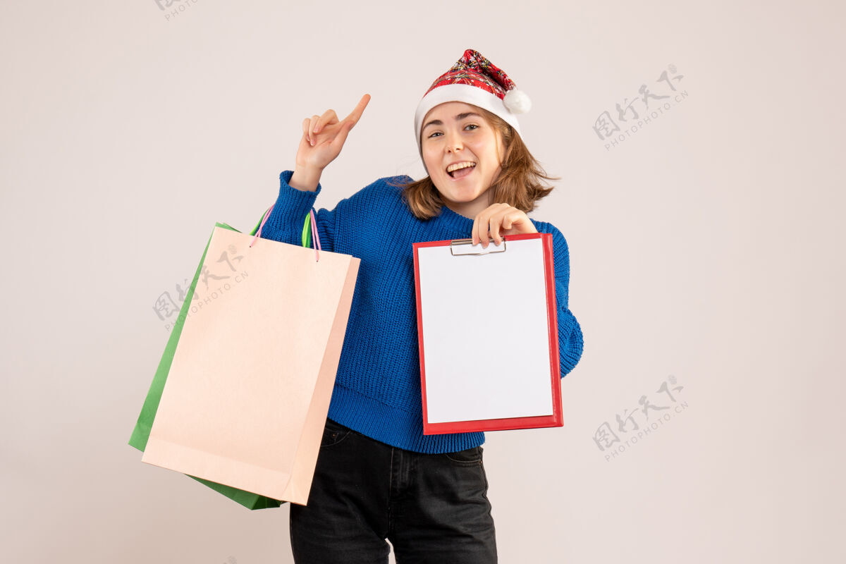 笔记年轻女子拿着购物包和纸条上的白色年轻女性盒子圣诞节