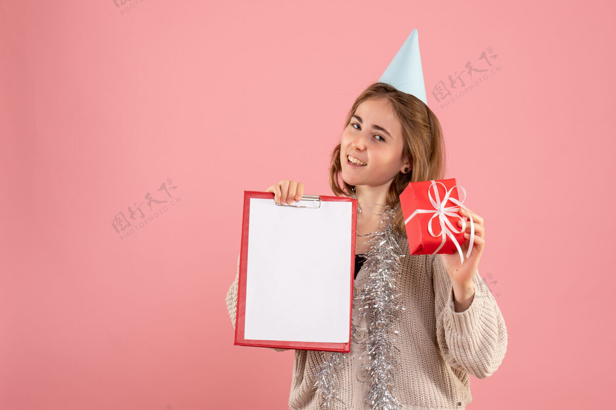 年轻的女性年轻的女性拿着小圣诞礼物和粉红色的纸条便条女人礼物