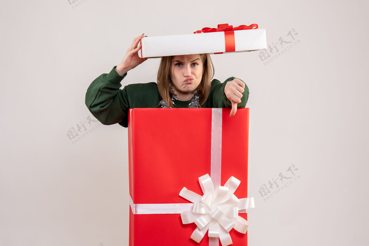 圣诞年轻的女性躲在白色的礼物盒里包年轻女性礼物