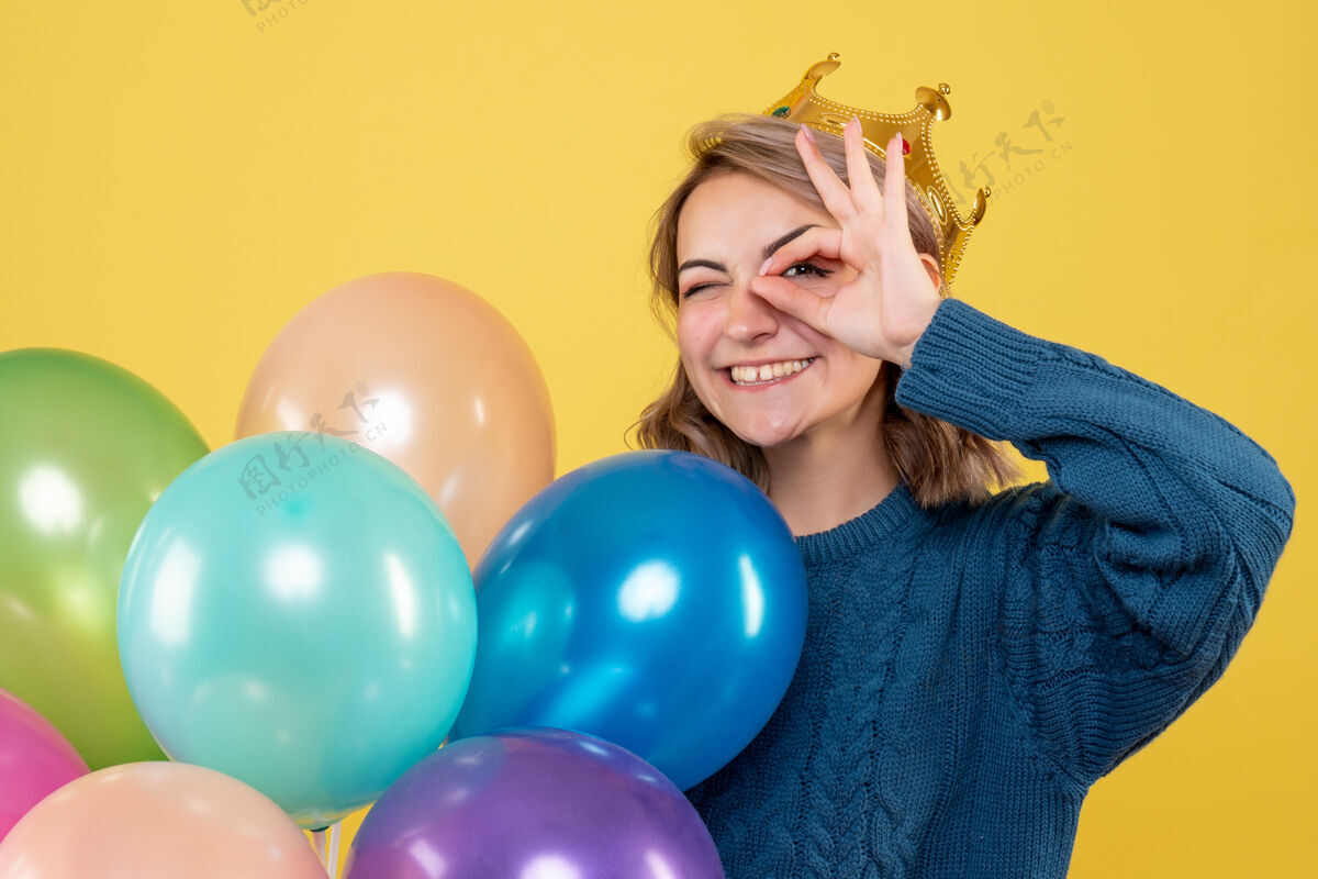 圣诞节年轻的女性手持黄色的皇冠气球工艺庆祝视图