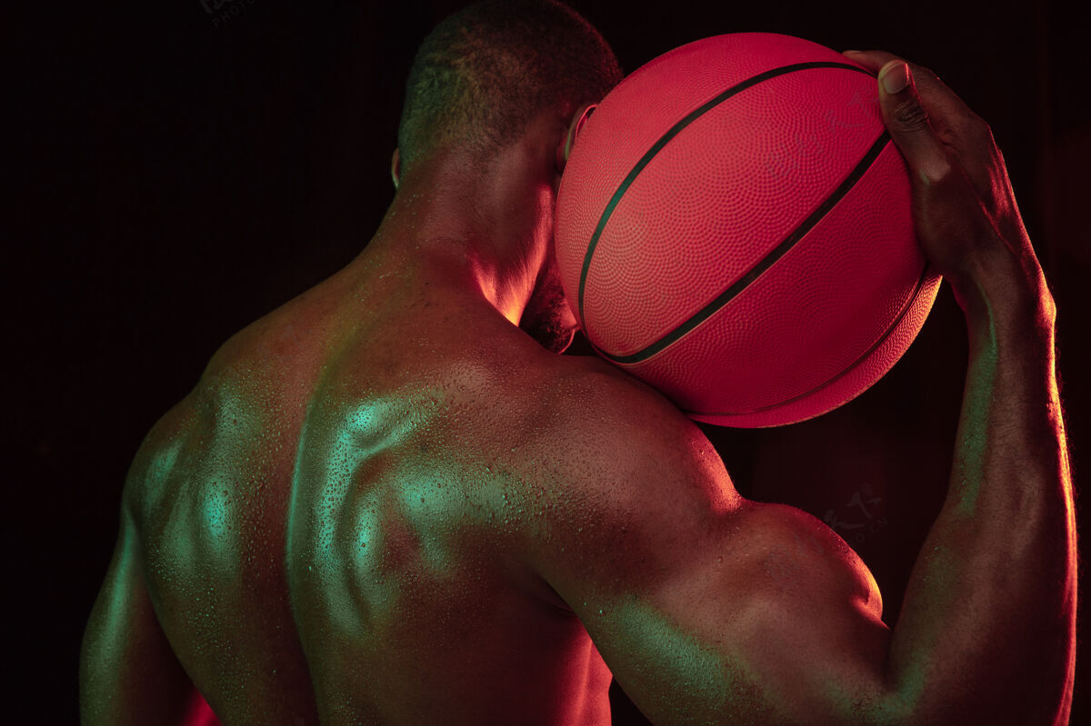 球场美国黑人肌肉发达的年轻篮球运动员在比赛中的动作训练男性篮球霓虹灯