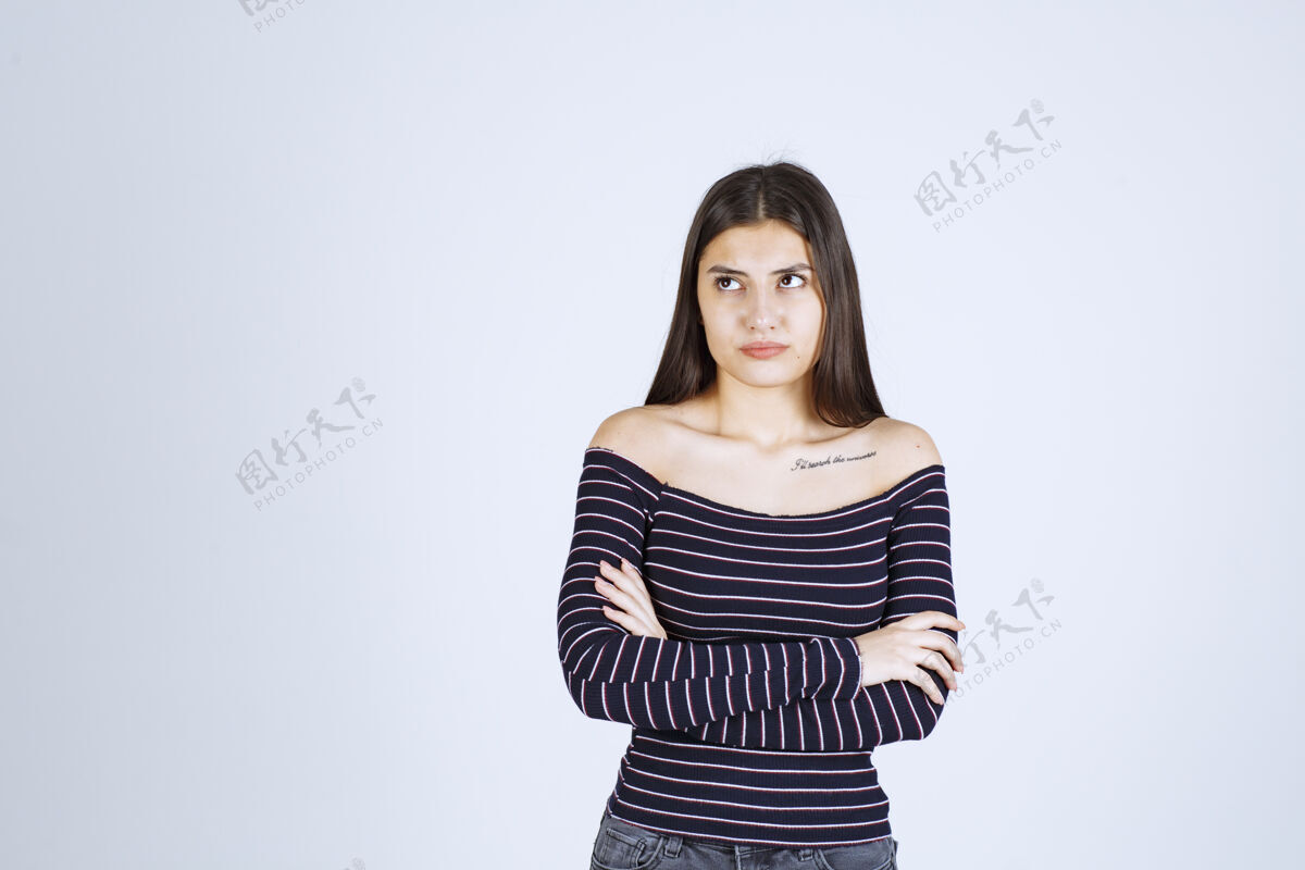人类穿条纹衬衫的年轻女子双臂交叉 表情严肃聪明休闲人