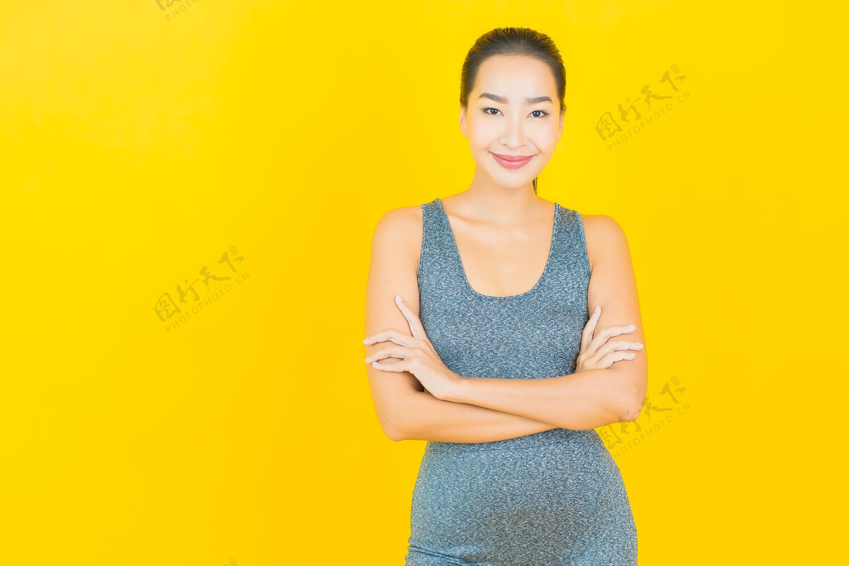 欢呼在黄色的墙上 描绘一位穿着运动服准备锻炼的美丽亚洲年轻女子穿着日本人训练
