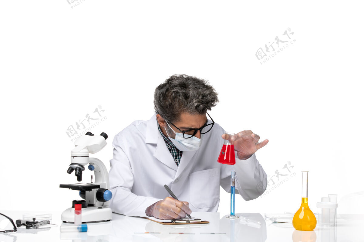 技师正面图穿着特殊套装的中年科学家坐着拿着装有红色溶液的烧瓶临床化学医学
