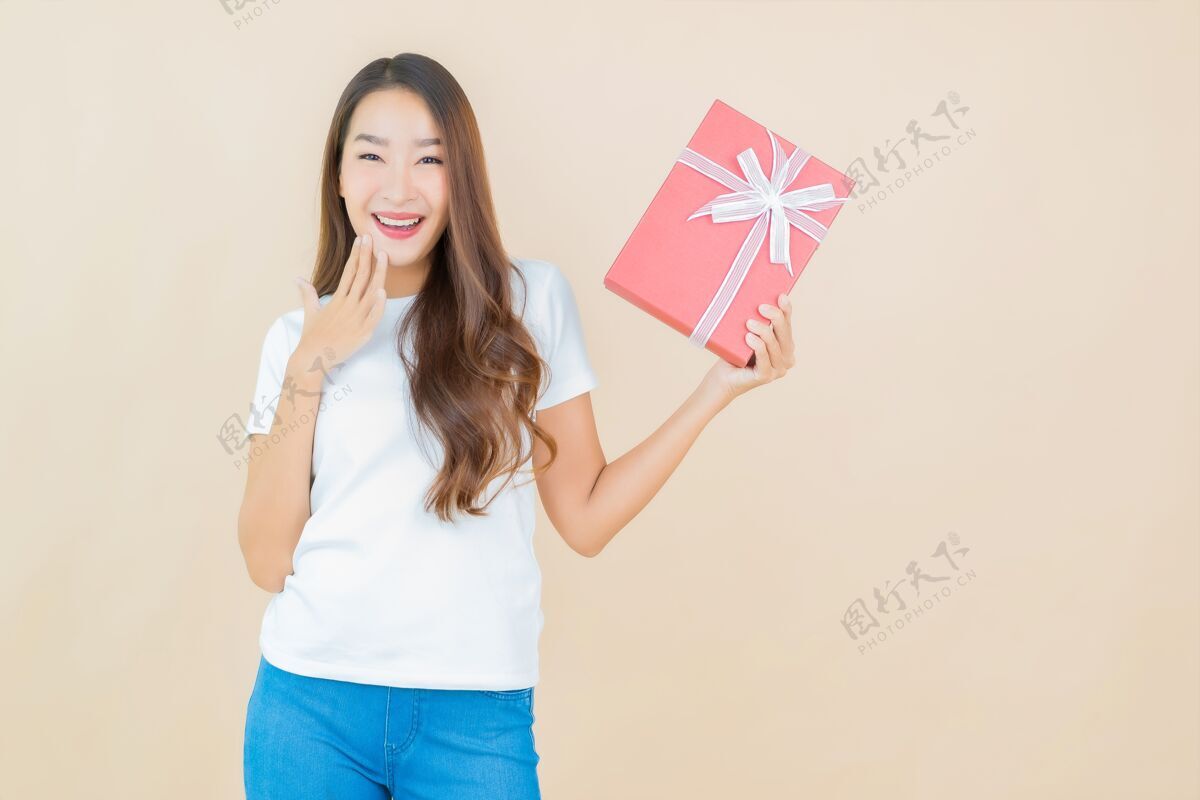 礼物肖像美丽的亚洲年轻女子与红色礼盒米色欢呼女士礼物