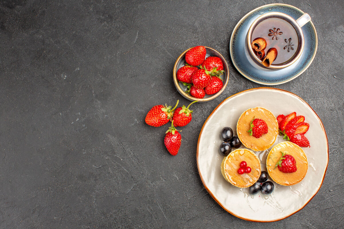 茶顶视图小美味的水果煎饼和一杯茶的灰色表面馅饼蛋糕水果美味视图碗