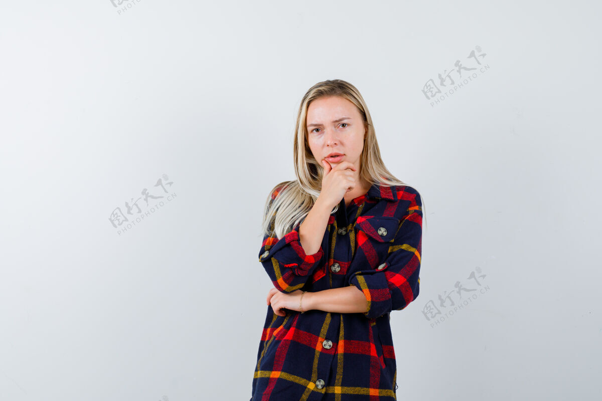 时尚年轻的女士穿着格子衬衫站在思考的姿势 看起来沉思 前视图人模特自然