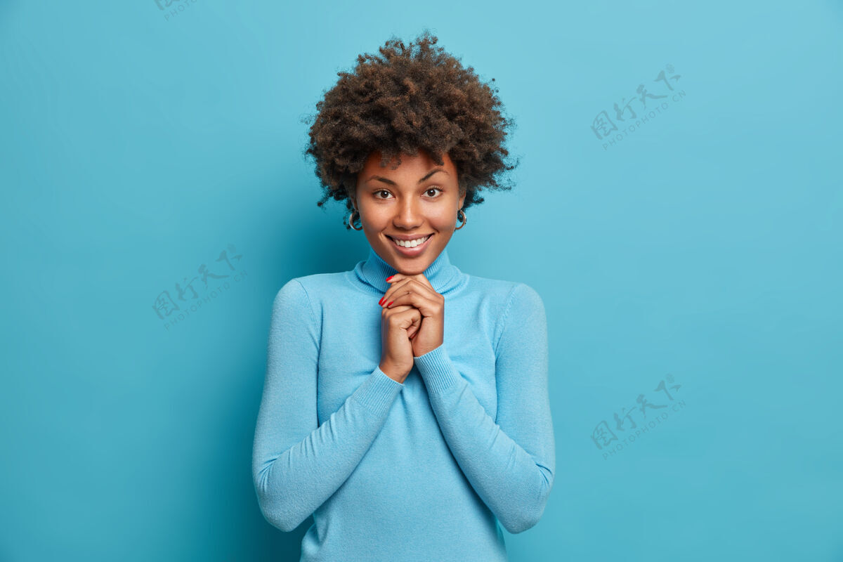人快乐女孩的肖像有着非洲式的头发双手托在下巴下 表情愉快满意非洲成人乐观