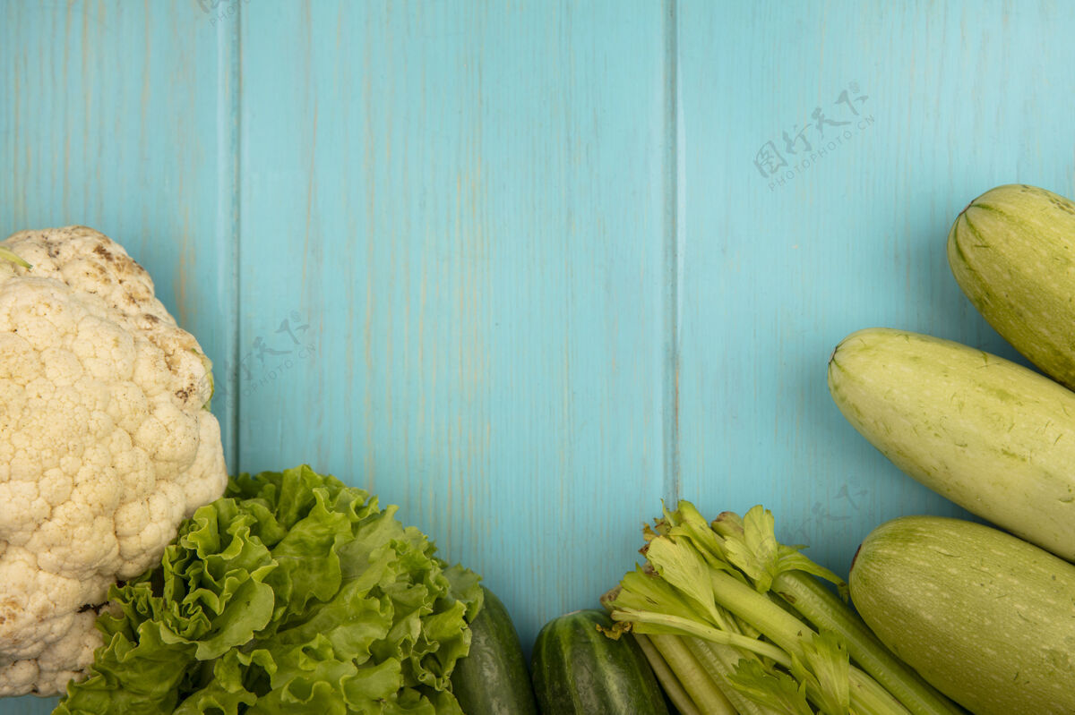 西葫芦新鲜蔬菜的俯视图 如花椰菜 黄瓜 莴苣 西葫芦和芹菜 隔离在蓝色的木墙上 留有复制空间芹菜木材黄瓜