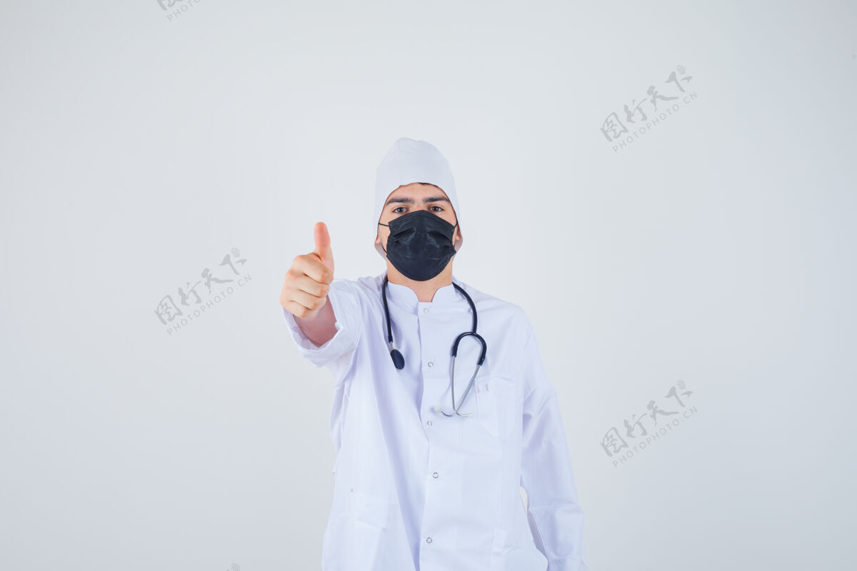 医学身穿白色制服 戴着面具 表情坚定的年轻人竖起大拇指正视图肖像专家人