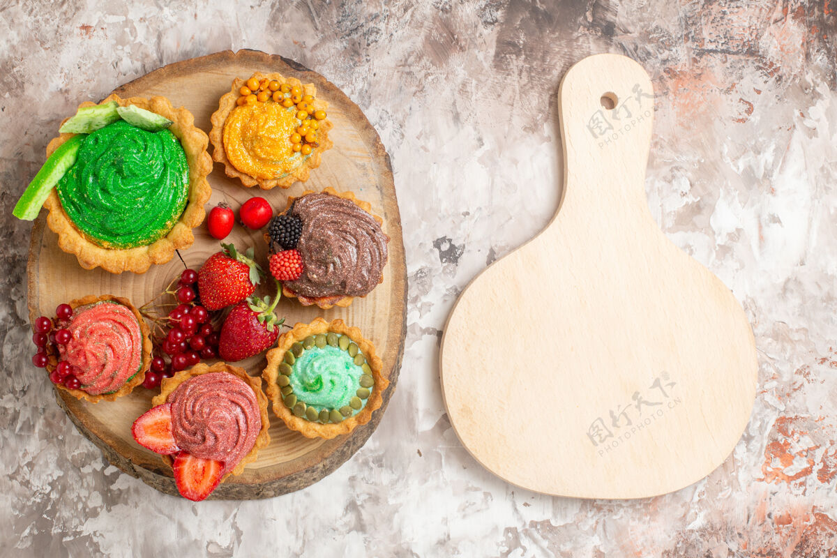 饼干俯瞰美味的奶油蛋糕和水果放在浅色桌上甜点饼干甜蛋糕蛋糕胡椒粉食物