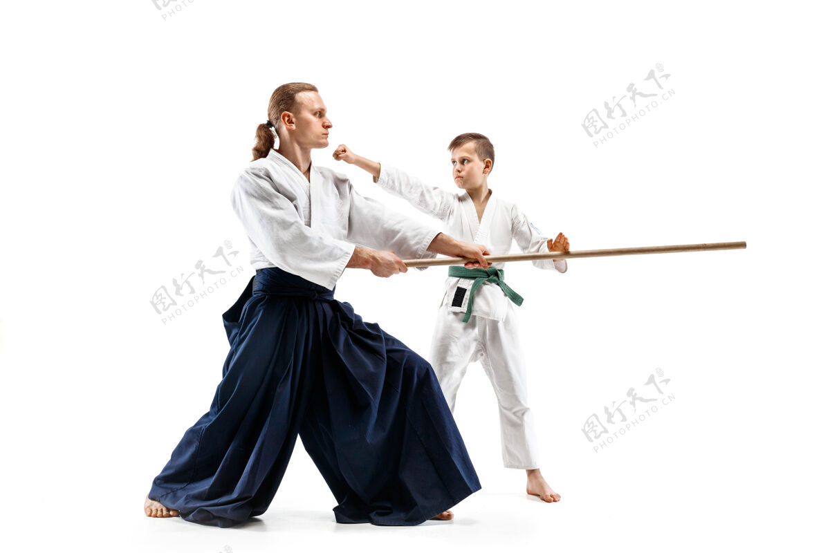 裙子男子和少年男孩在武术学校的合气道训练中用木剑搏斗日本人大师木头