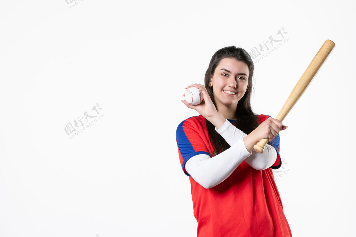 微笑前视图：带球棒和球的女棒球运动员成人年轻支持
