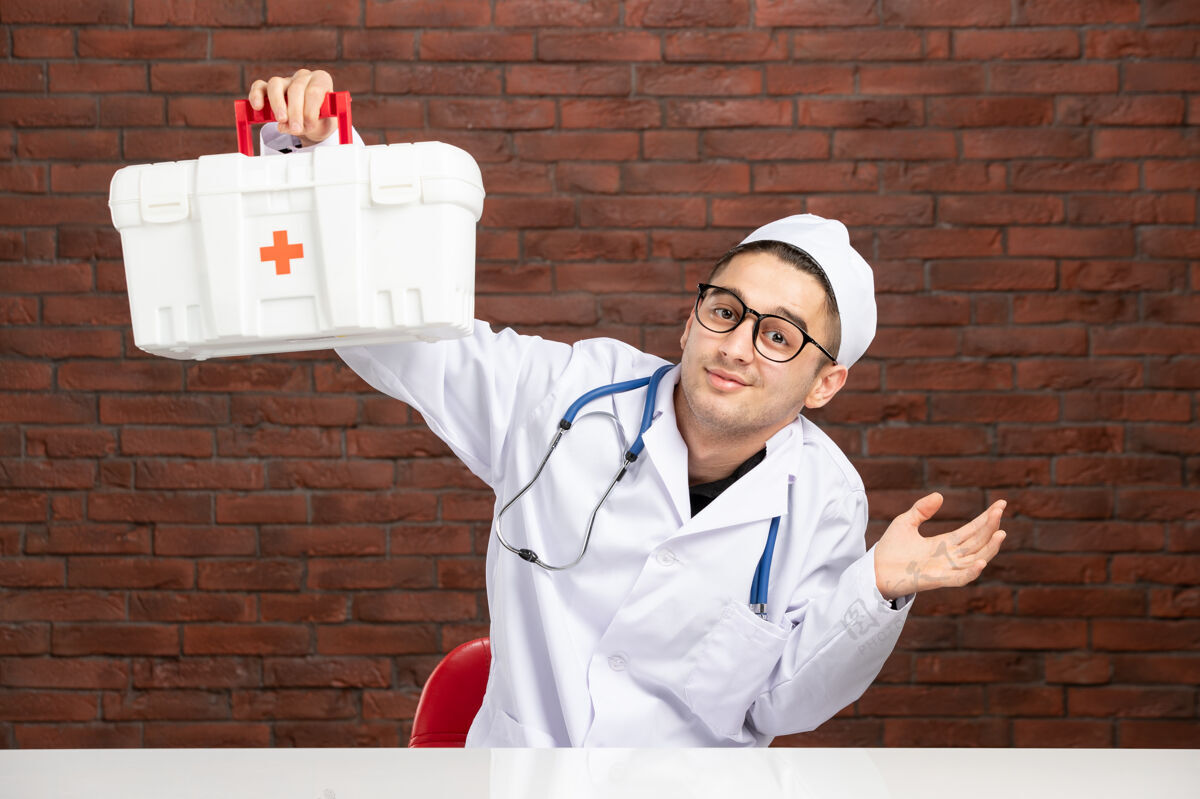前面前视图身穿白色医疗服的年轻医生带着急救箱医学工具包西装