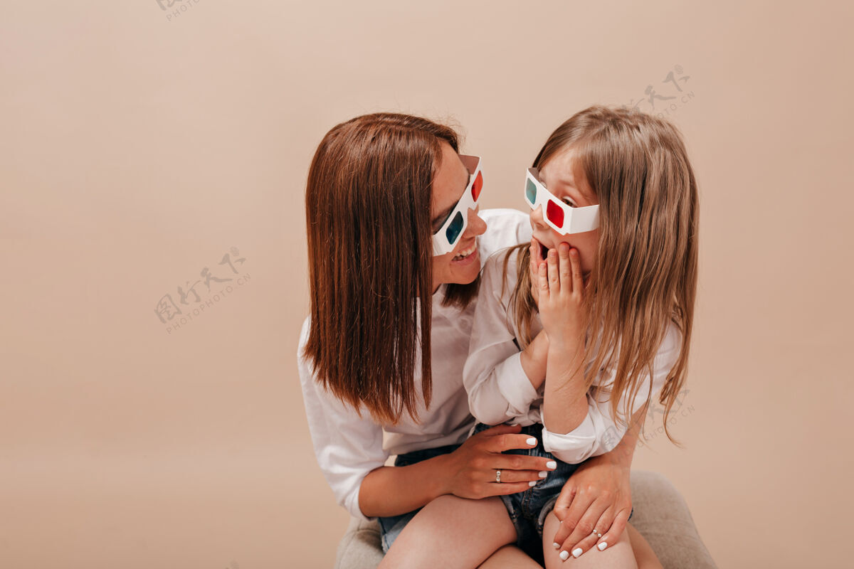 电影女人抱着她可爱的小女孩戴着眼镜看电影小女孩和她的妈妈一起看电影老年人感激成熟