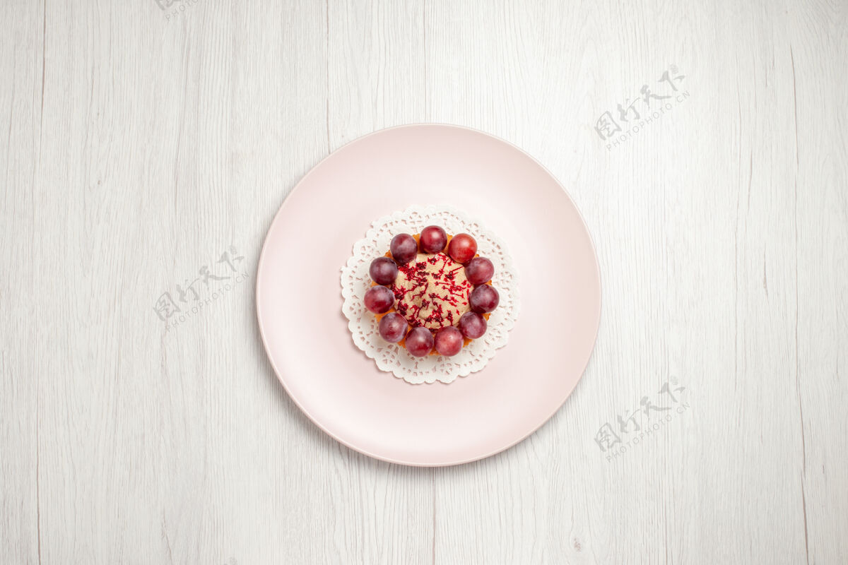 小蛋糕顶视图小蛋糕与葡萄内盘上的白色水果甜点蛋糕美味浆果膳食
