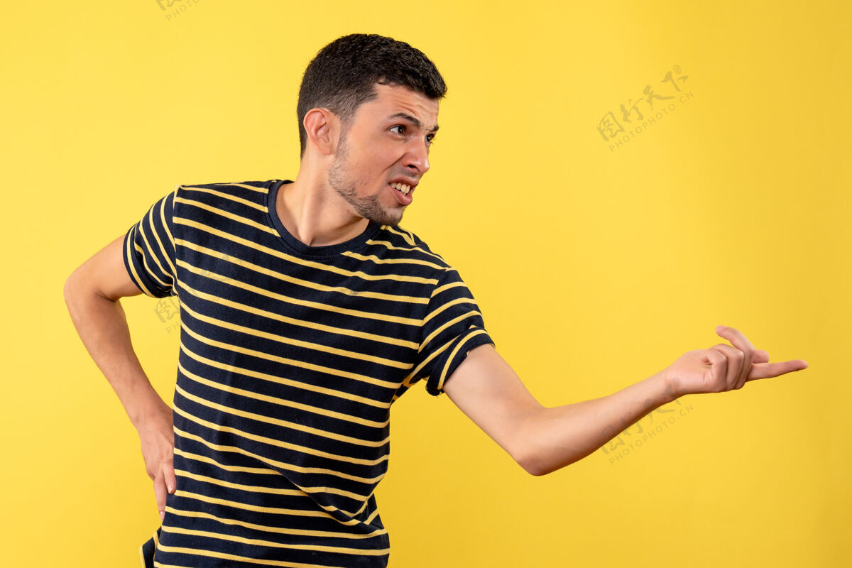 肖像正面图身穿黑白条纹t恤的年轻人把手放在黄色隔离背景上的腰部成人条纹视图