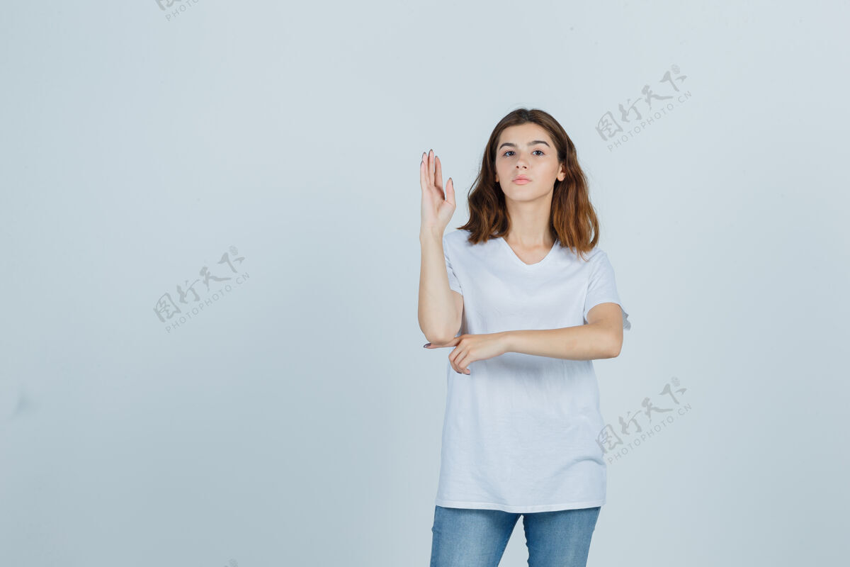 人穿着白色t恤的年轻女孩举手 看起来很自信 正面照护理性感自信