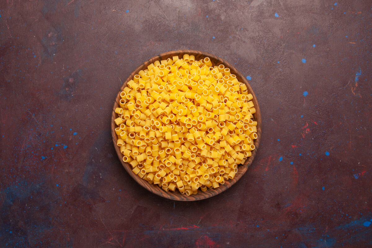 晚餐顶视图黄色意大利面食生面团在深色背景上形成面食生面团面团美味豆类