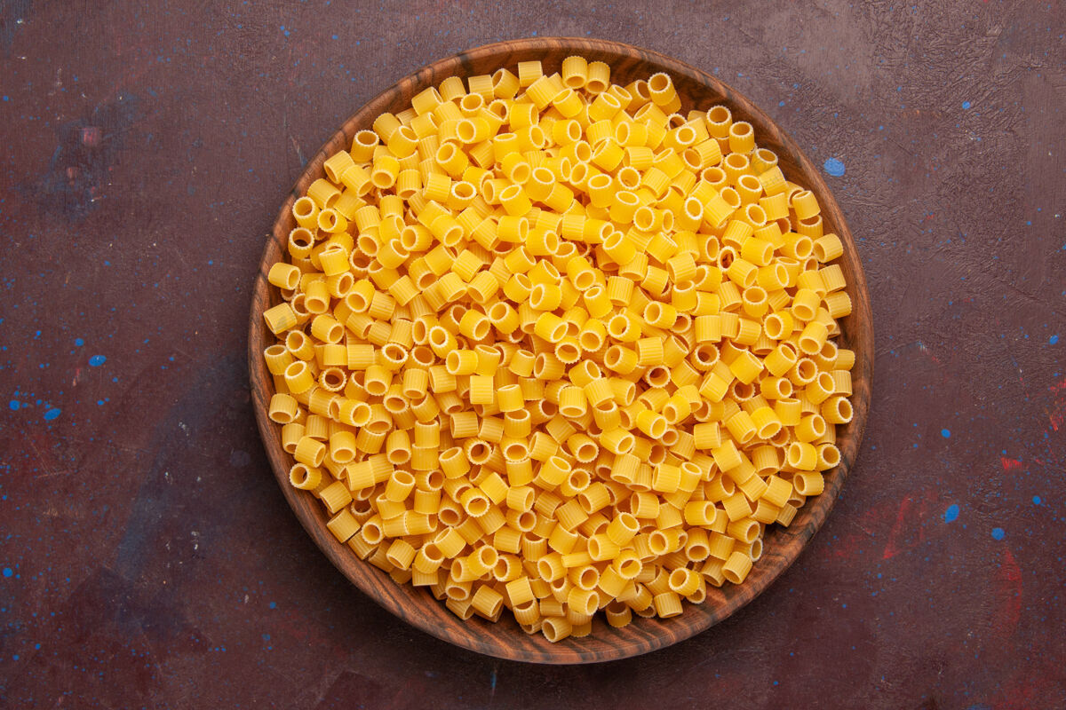 面团顶视图黄色意大利面食生面团在深色背景上形成一点意大利面食生面团意大利内核食物